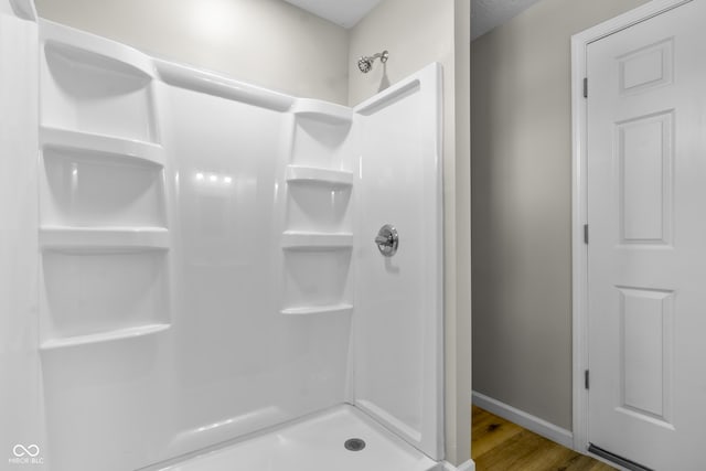 418 Harlan St, Indianapolis, IN 46201 - bathroom with a stall shower, wood finished floors, and baseboards
