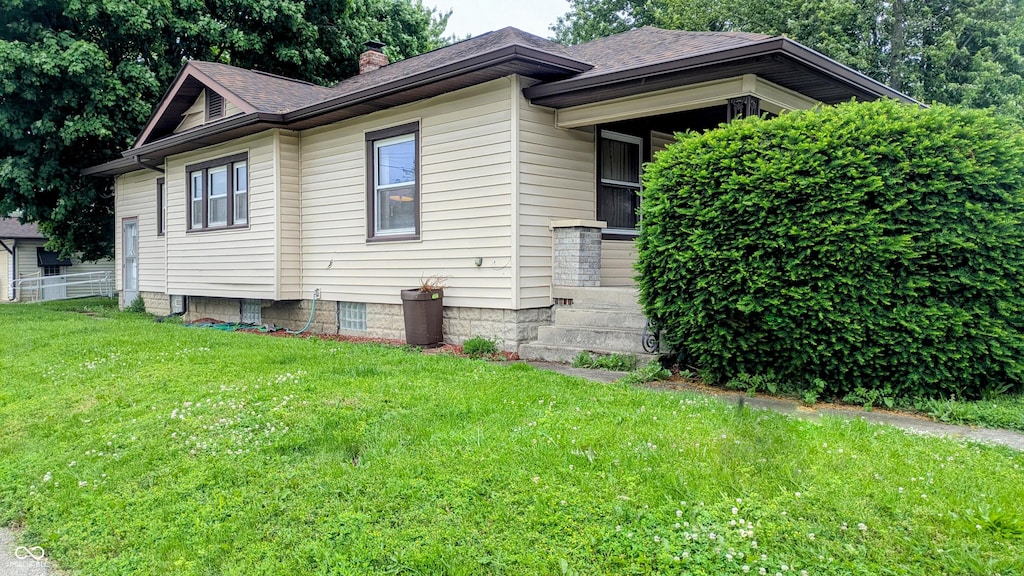 100 N 6th Ave, Beech Grove, IN 46107 - view of property exterior featuring a chimney, a lawn, and roof with shingles