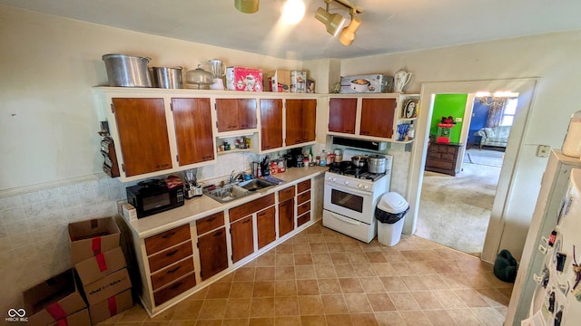 100 N 6th Ave, Beech Grove, IN 46107 - kitchen featuring gas range gas stove, a sink, range hood, and brown cabinets