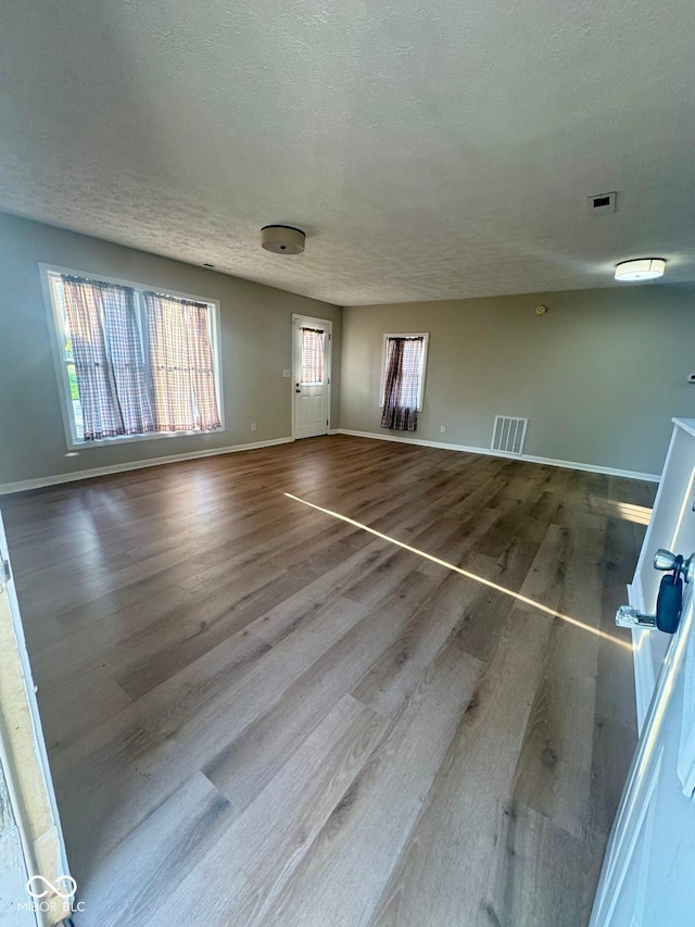 2931 Byrkit St, Indianapolis, IN 46217 - unfurnished living room with wood finished floors and a textured ceiling