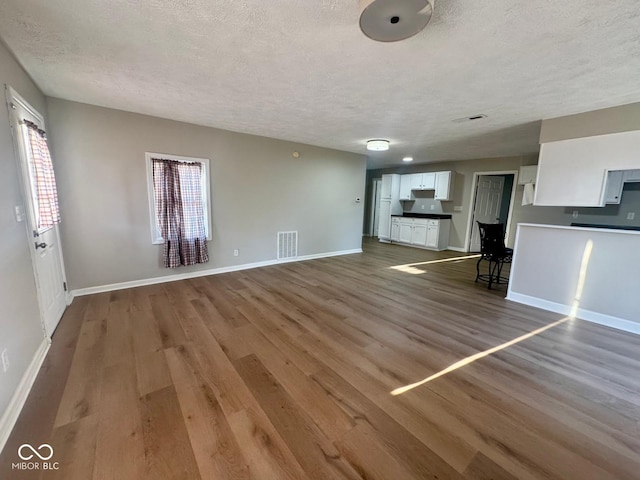 2931 Byrkit St, Indianapolis, IN 46217 - unfurnished living room with a textured ceiling and wood finished floors