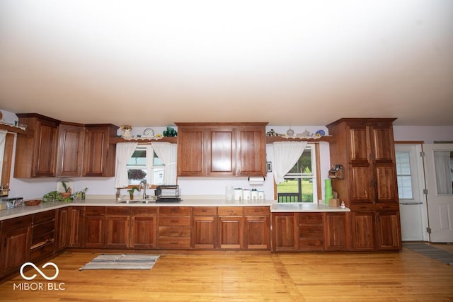 6190 E County Road 800 N, North Vernon, IN 47265 - kitchen with light countertops, a sink, light wood finished floors, and brown cabinets