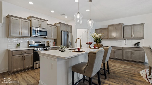 14866 E Keenan Cir Lot 38, Westfield, IN 46074 - kitchen with stainless steel appliances, a sink, a breakfast bar, backsplash, and an island with sink
