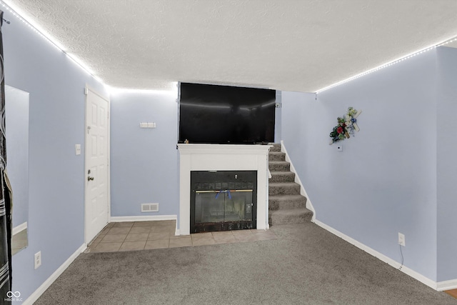 7915 Broadview Dr, Indianapolis, IN 46227 - unfurnished living room with a fireplace with flush hearth, carpet flooring, a textured ceiling, stairway, and tile patterned floors