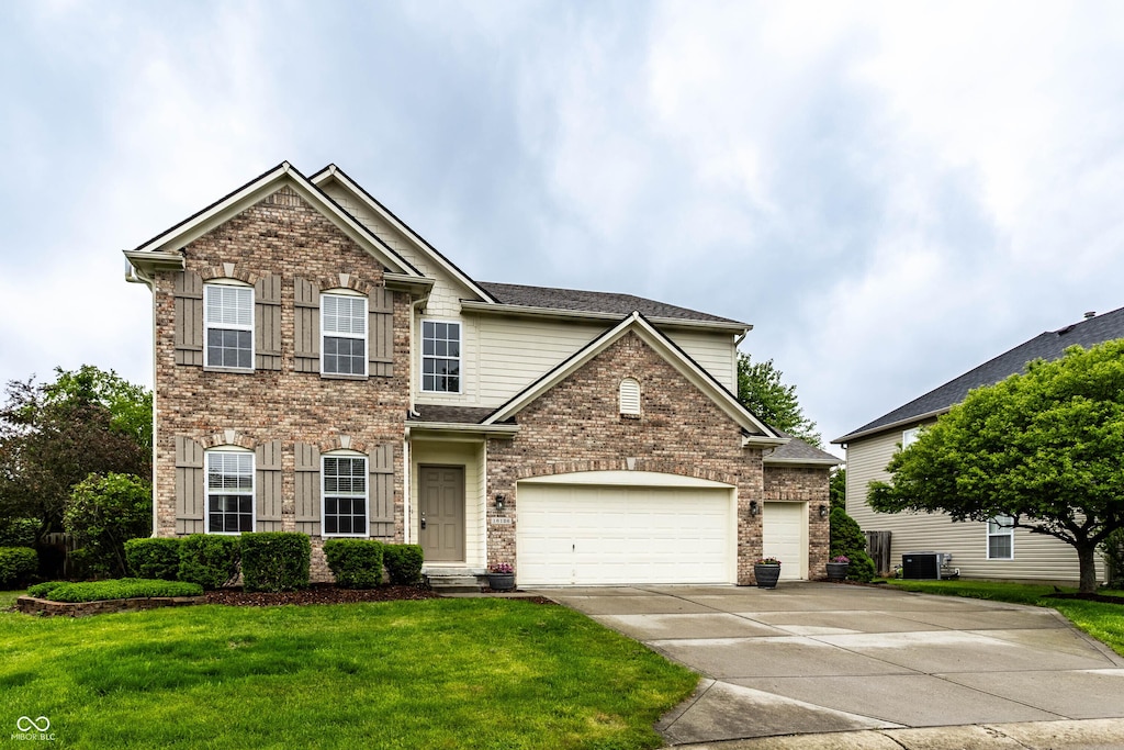 16126 Etna Grn, Westfield, IN 46074 - traditional-style home featuring a front lawn, concrete driveway, cooling unit, brick siding, and a garage