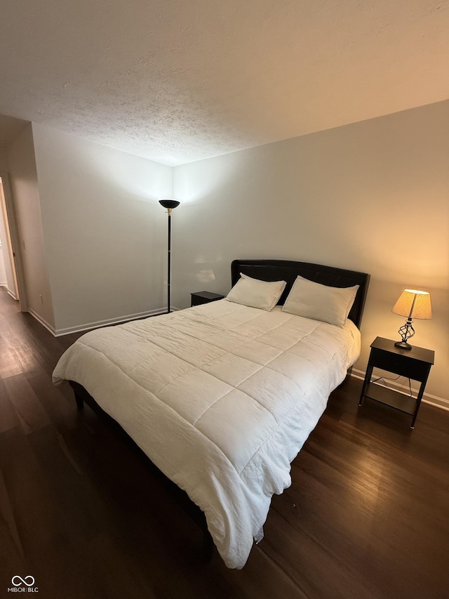 9535 Longwell Dr, Indianapolis, IN 46240 - bedroom featuring dark wood-style floors, baseboards, and a textured ceiling