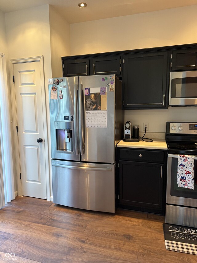 9535 Longwell Dr, Indianapolis, IN 46240 - kitchen with appliances with stainless steel finishes, dark cabinets, wood finished floors, and recessed lighting