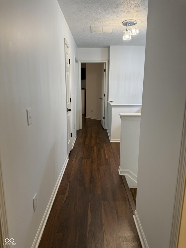 9535 Longwell Dr, Indianapolis, IN 46240 - hall featuring dark wood-style flooring, a textured ceiling, and baseboards