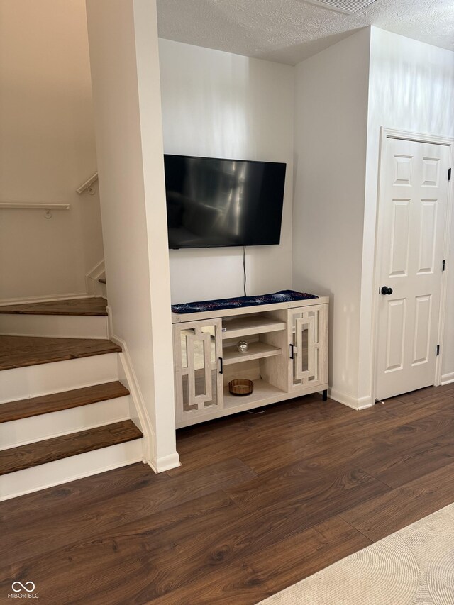 9535 Longwell Dr, Indianapolis, IN 46240 - unfurnished living room featuring dark wood finished floors, stairway, baseboards, and a textured ceiling