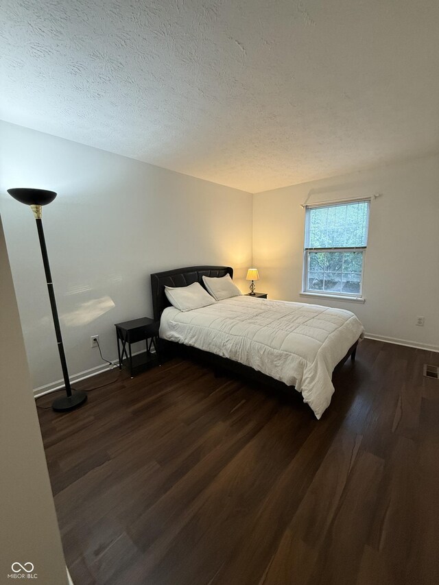 9535 Longwell Dr, Indianapolis, IN 46240 - bedroom featuring wood finished floors, baseboards, and a textured ceiling