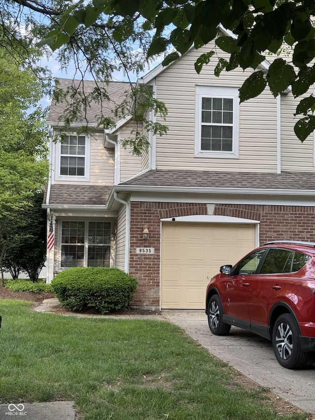 9535 Longwell Dr, Indianapolis, IN 46240 - view of front of house featuring a garage, driveway, a front yard, brick siding, and roof with shingles