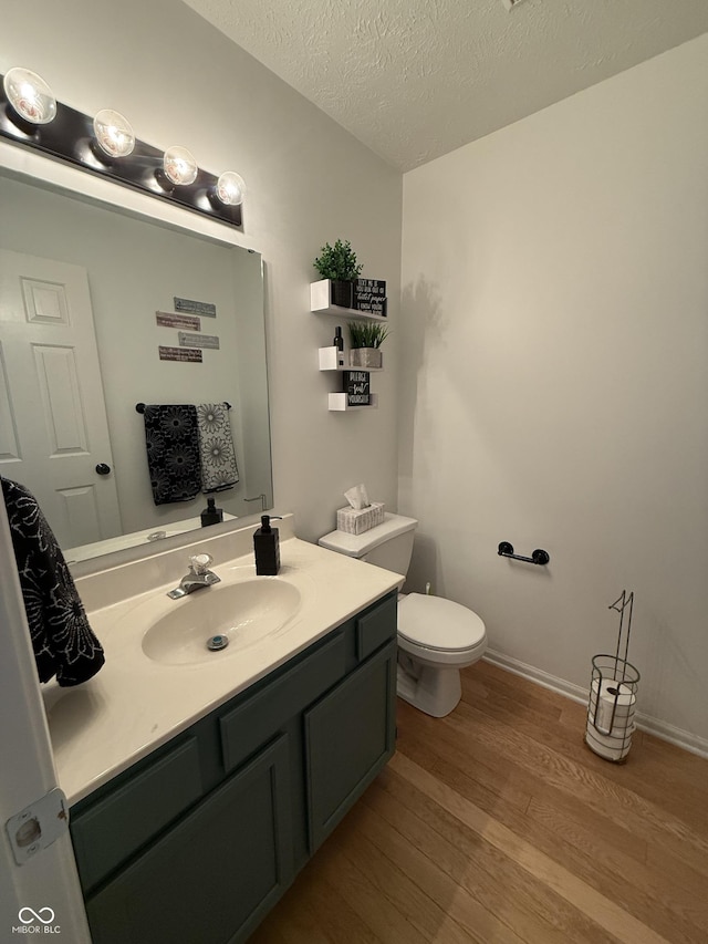 9535 Longwell Dr, Indianapolis, IN 46240 - half bath with wood finished floors, vanity, toilet, a textured ceiling, and baseboards