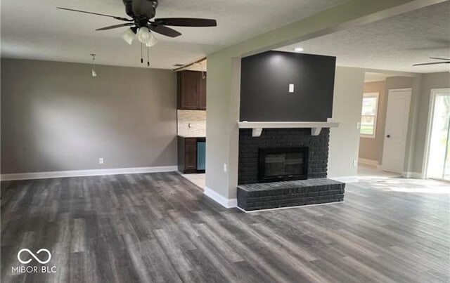 7731 Scarborough Blvd S, Indianapolis, IN 46256 - unfurnished living room featuring ceiling fan, dark wood-style flooring, baseboards, and a fireplace
