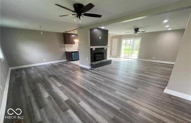 7731 Scarborough Blvd S, Indianapolis, IN 46256 - unfurnished living room with baseboards, a ceiling fan, dark wood-style flooring, and a brick fireplace
