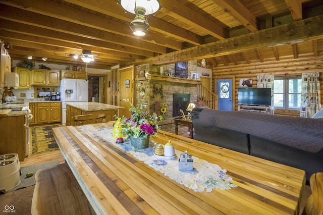 10484 N County Road 750 W, Freetown, IN 47235 - dining room with dark wood-type flooring, a fireplace, wooden ceiling with exposed beams, ceiling fan, and rustic walls