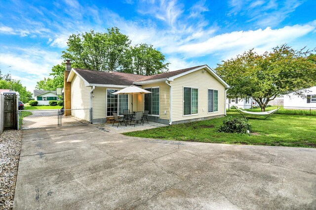356 Daugherty St, Columbus, IN 47201 - back of property with a gate, a chimney, driveway, and a patio