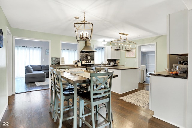356 Daugherty St, Columbus, IN 47201 - kitchen featuring dark countertops, stainless steel stove, backsplash, white cabinets, and a chandelier