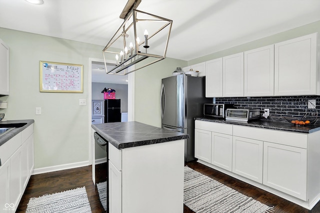 356 Daugherty St, Columbus, IN 47201 - kitchen featuring dark countertops, dark wood-type flooring, white cabinetry, a center island, and decorative backsplash