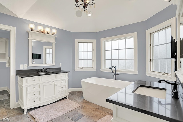 3398 Nottinghill Blvd, Plainfield, IN 46168 - full bathroom with vanity, baseboards, a freestanding bath, and stone tile flooring