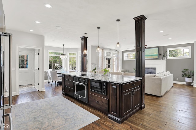 3398 Nottinghill Blvd, Plainfield, IN 46168 - kitchen with black appliances, dark wood-style floors, a glass covered fireplace, baseboards, and recessed lighting