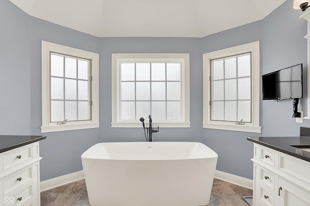 3398 Nottinghill Blvd, Plainfield, IN 46168 - bathroom with vanity, baseboards, stone tile flooring, and a freestanding bath