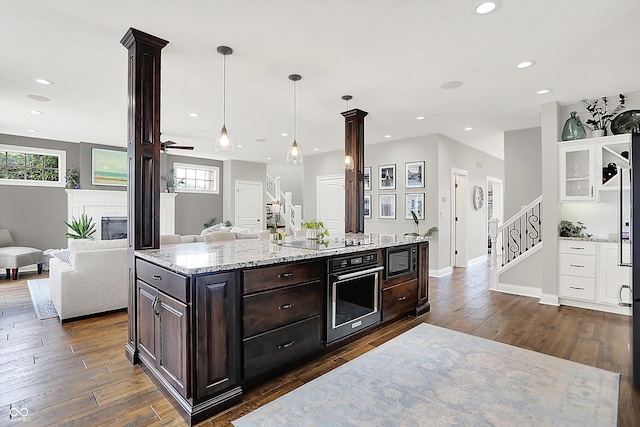 3398 Nottinghill Blvd, Plainfield, IN 46168 - kitchen with black appliances, dark brown cabinets, dark wood finished floors, open floor plan, and recessed lighting