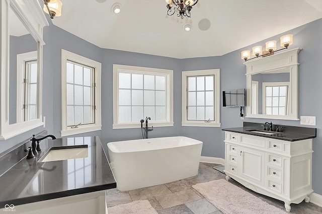 3398 Nottinghill Blvd, Plainfield, IN 46168 - bathroom featuring a freestanding bath, vanity, baseboards, and stone tile flooring