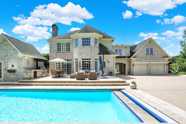 3398 Nottinghill Blvd, Plainfield, IN 46168 - back of property with exterior kitchen, an outdoor hangout area, an outdoor pool, and an attached garage