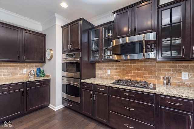 2436 Gwinnett St, Carmel, IN 46032 - kitchen with stainless steel appliances, crown molding, dark wood finished floors, decorative backsplash, and light stone counters
