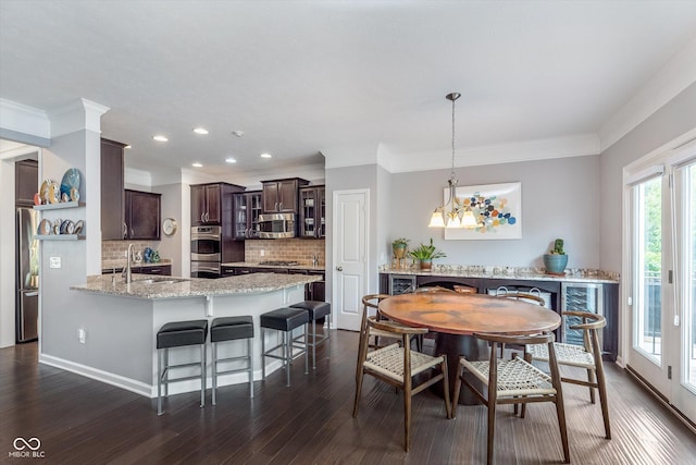 2436 Gwinnett St, Carmel, IN 46032 - dining space featuring dark wood-style flooring, ornamental molding, recessed lighting, and a chandelier