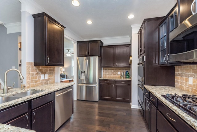 2436 Gwinnett St, Carmel, IN 46032 - kitchen featuring stainless steel appliances, a sink, crown molding, tasteful backsplash, and light stone countertops
