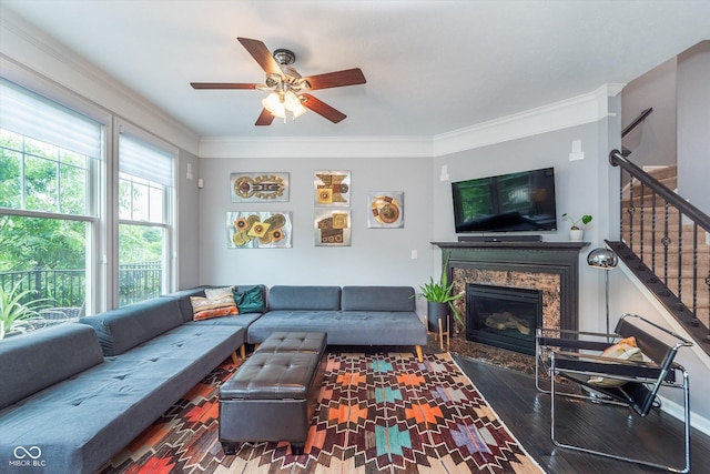 2436 Gwinnett St, Carmel, IN 46032 - living room with wood finished floors, ceiling fan, a fireplace, stairway, and ornamental molding