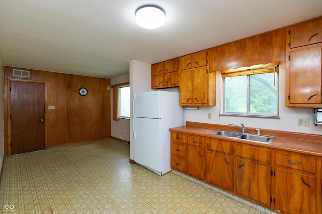 6498 N County Road 475 E, Pittsboro, IN 46167 - kitchen featuring freestanding refrigerator, a sink, brown cabinets, wooden walls, and light floors