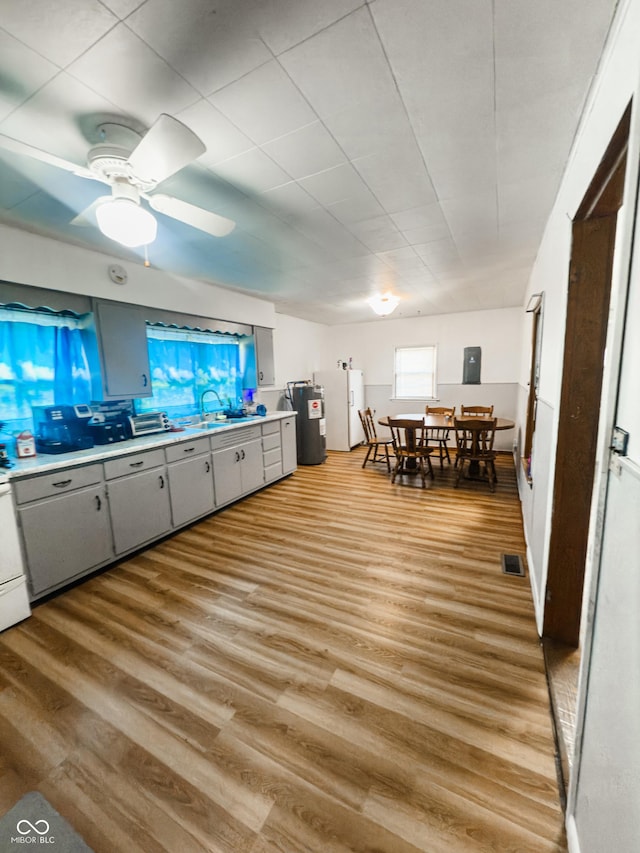 3385 W Commerce St, Vallonia, IN 47281 - kitchen featuring gray cabinets, light countertops, light wood-style flooring, a sink, and refrigerator