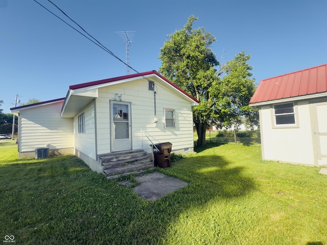 3385 W Commerce St, Vallonia, IN 47281 - back of property with entry steps, a lawn, and central AC unit