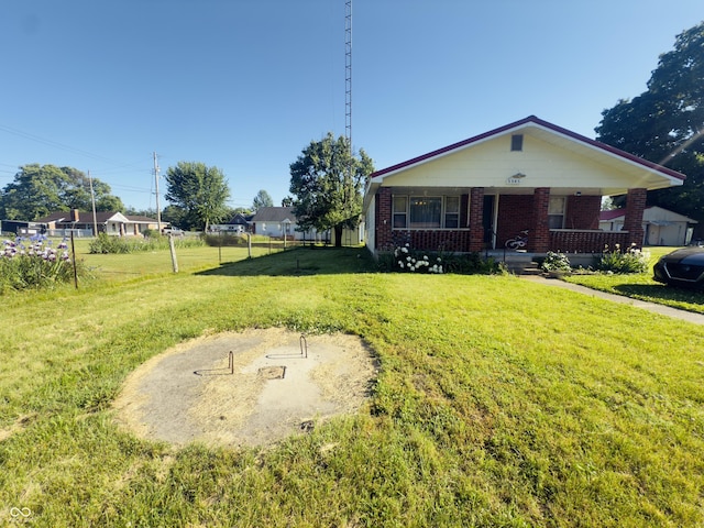 3385 W Commerce St, Vallonia, IN 47281 - bungalow with brick siding, covered porch, and a front lawn