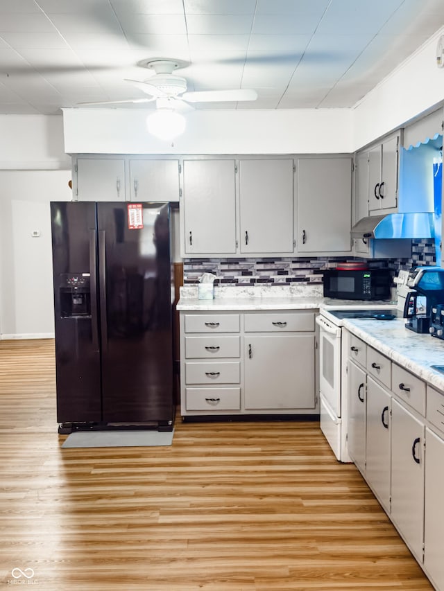 3385 W Commerce St, Vallonia, IN 47281 - kitchen featuring black appliances, ceiling fan, under cabinet range hood, light countertops, and light wood-style flooring