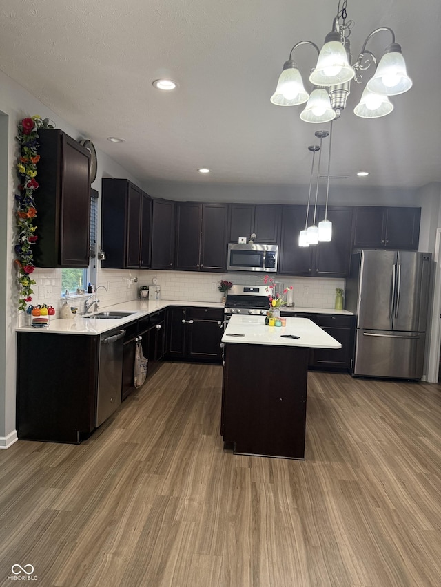 8241 Morera Ct, Indianapolis, IN 46237 - kitchen featuring stainless steel appliances, light countertops, wood finished floors, tasteful backsplash, and a center island