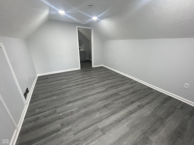 2911 E 35th St, Indianapolis, IN 46218 - bonus room featuring dark wood-type flooring, lofted ceiling, baseboards, and a textured ceiling