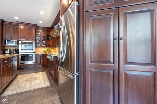 876 Box Turtle Ct, Columbus, IN 47201 - kitchen with appliances with stainless steel finishes, recessed lighting, dark tile patterned flooring, tasteful backsplash, and glass insert cabinets