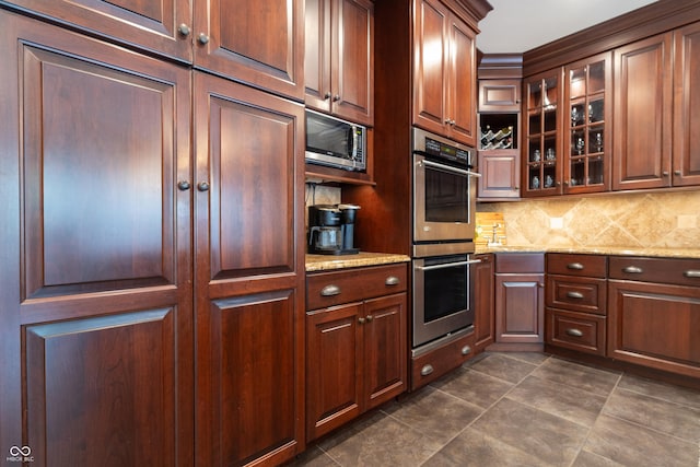 876 Box Turtle Ct, Columbus, IN 47201 - kitchen with appliances with stainless steel finishes, glass insert cabinets, light stone countertops, and decorative backsplash