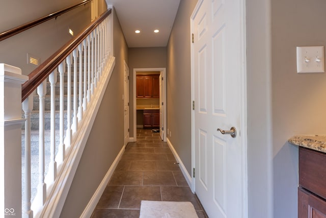 876 Box Turtle Ct, Columbus, IN 47201 - hallway featuring baseboards, recessed lighting, dark tile patterned floors, a sink, and stairs