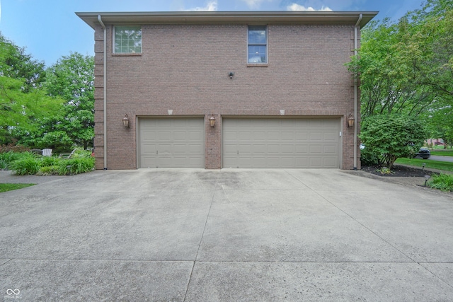 876 Box Turtle Ct, Columbus, IN 47201 - view of property exterior featuring an attached garage, driveway, and brick siding