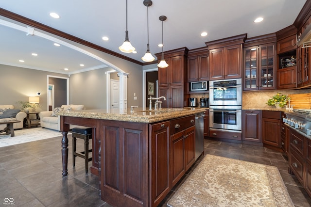 876 Box Turtle Ct, Columbus, IN 47201 - kitchen featuring appliances with stainless steel finishes, decorative columns, recessed lighting, crown molding, and a kitchen breakfast bar