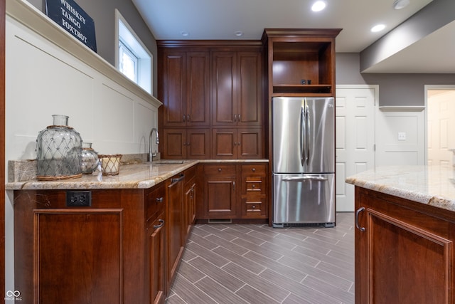 876 Box Turtle Ct, Columbus, IN 47201 - kitchen with freestanding refrigerator, a sink, light stone countertops, open shelves, and a decorative wall