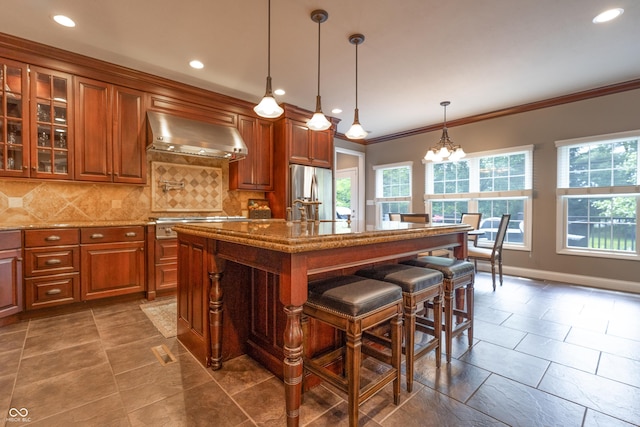 876 Box Turtle Ct, Columbus, IN 47201 - kitchen with wall chimney range hood, stainless steel appliances, brown cabinets, backsplash, and crown molding