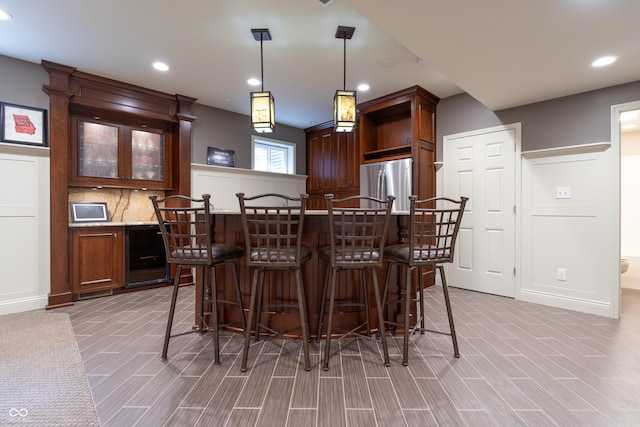 876 Box Turtle Ct, Columbus, IN 47201 - kitchen with freestanding refrigerator, a breakfast bar, glass insert cabinets, recessed lighting, and decorative light fixtures