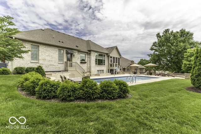 7648 Killarney Dr, Indianapolis, IN 46217 - rear view of house featuring brick siding, a yard, an outdoor pool, and roof with shingles