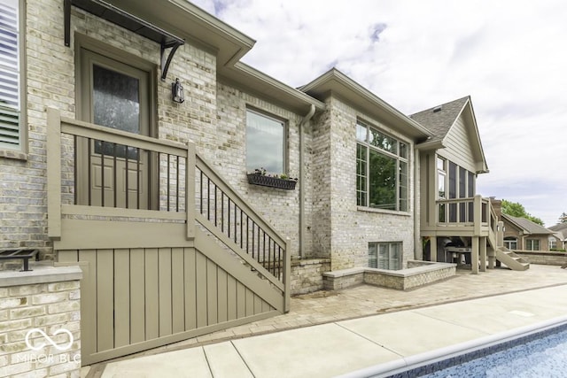 7648 Killarney Dr, Indianapolis, IN 46217 - view of exterior entry with a patio, brick siding, and a shingled roof