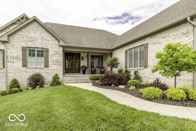 7648 Killarney Dr, Indianapolis, IN 46217 - view of front of house featuring roof with shingles, brick siding, french doors, and a front yard